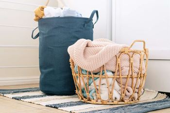 a basket of clothes next to a blue laundry bag  at Timber Glen Apartments, Ohio, 45103
